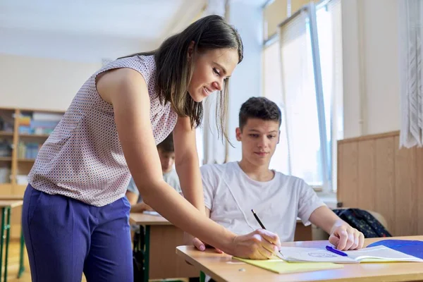 Ung kvinnolärare lär ut lektion i tonårsbarns klass — Stockfoto