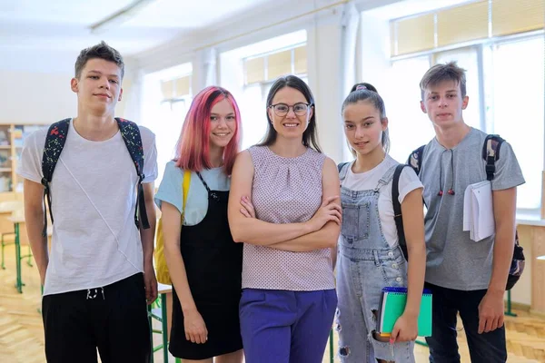 Group of teenagers with teacher, portrait of students and tutor in classroom — Stock Photo, Image