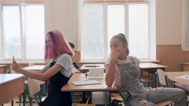 Skupina dospívajících dětí ve třídě se baví během přestávky mezi lekcemi — Stock video