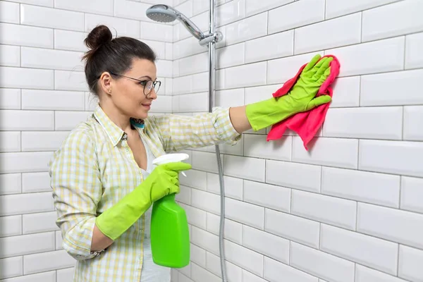 Banyo temizliği, ev hanımı beyaz fayans duvarını deterjan ve bez parçasıyla yıkıyor. — Stok fotoğraf