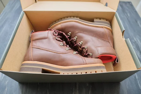 Nuevas botas de invierno impermeables de cuero marrón para mujer en caja —  Fotos de Stock