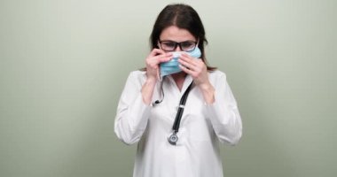Steteskoplu, kendinden emin, olgun bir doktorun portresi. Kadın, tıbbi koruyucu maske takıyor.