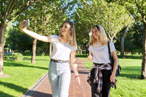 Twee gelukkig tiener meisjes op zoek naar webcam van smartphone — Stockfoto