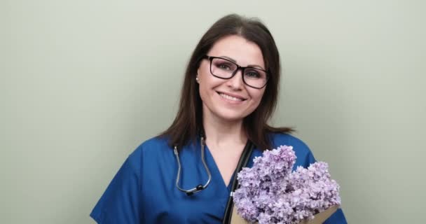 Doctors Day, celebration. Happy smiling female medic with bouquet of flowers — Stock Video