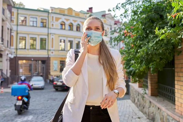 Retrato de una joven mujer de negocios con máscara de protección médica hablando por teléfono celular —  Fotos de Stock