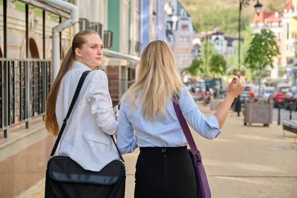 Tylne ujęcie dwóch młodych kobiet biznesu spacerujących i rozmawiających w mieście — Zdjęcie stockowe