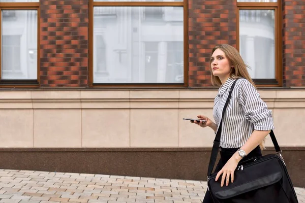 Joven mujer de negocios caminando hablando en smartphone al aire libre —  Fotos de Stock
