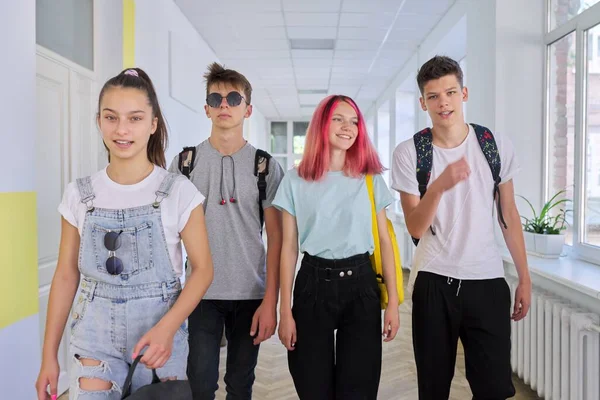 Groep tienerstudenten loopt samen langs schoolgang — Stockfoto