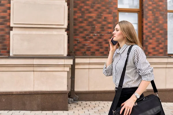 Jovem mulher de negócios andando com celular, perfil ver espaço cópia — Fotografia de Stock