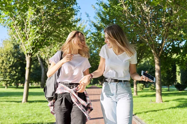 Две красивые счастливые девушки-подростки 17, 18 лет, гуляющие вместе в парке — стоковое фото