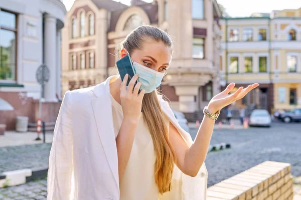 Retrato de una joven mujer de negocios con máscara de protección médica hablando por teléfono celular —  Fotos de Stock
