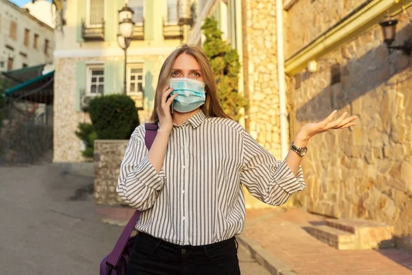 Joven mujer de negocios trabajadora de oficina en máscara de protección médica hablando en smartphone —  Fotos de Stock