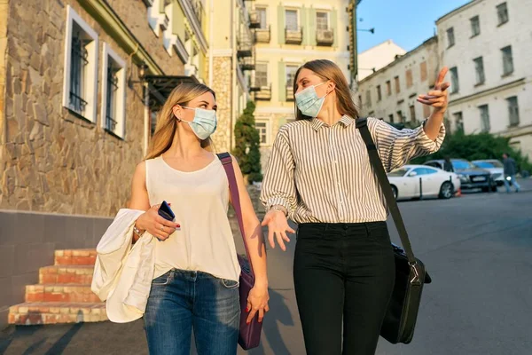 Trabajadores de oficina dos mujeres caminando, con máscaras médicas protectoras —  Fotos de Stock