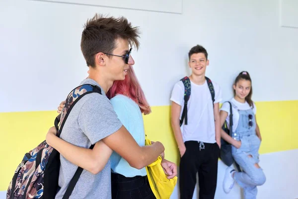 Incontro degli studenti adolescenti a scuola, saluto e abbraccio — Foto Stock