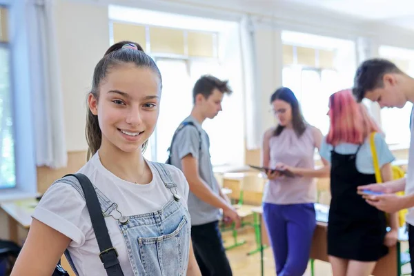 Portret van een lachend tienermeisje in de klas in de pauze — Stockfoto