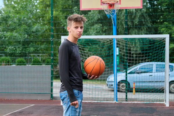 Szabadtéri portré tinédzser fiú labdával utcai kosárlabda pályán — Stock Fotó