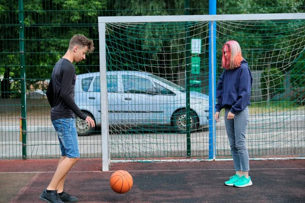 Tizenévesek fiú és lány játszik utcai kosárlabda együtt — Stock Fotó
