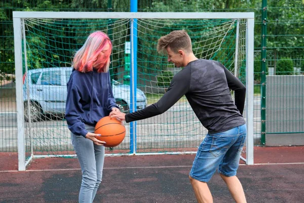 Tonåringar pojke och flicka spelar street basket tillsammans — Stockfoto