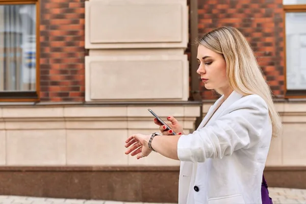 Młoda kobieta biznesu spaceruje po mieście rozmawiając przez telefon komórkowy — Zdjęcie stockowe