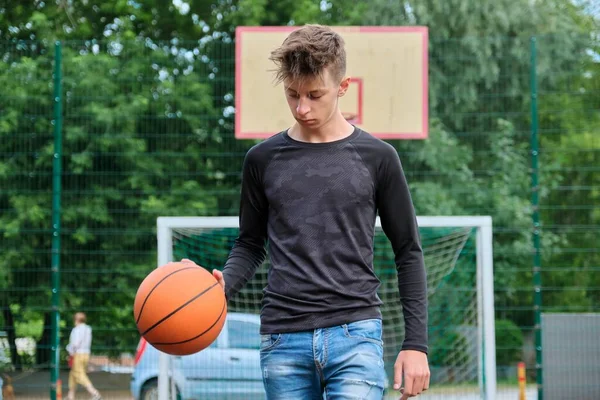 Outdoor portrait of teenage boy playing street basketball — Stock Photo, Image