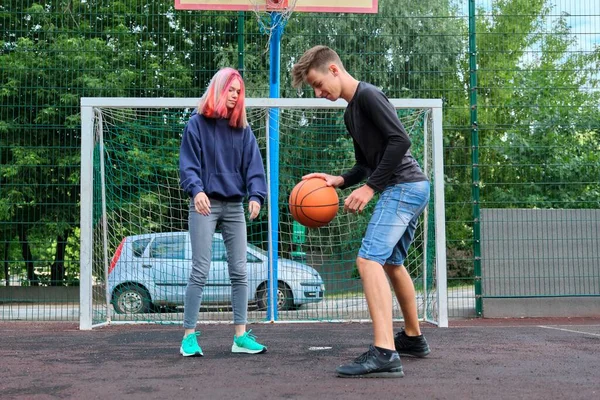 Tonåringar pojke och flicka spelar street basket tillsammans — Stockfoto