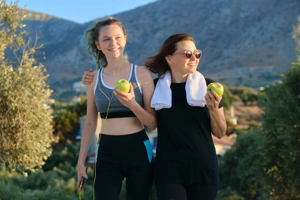 Atletisch gezond gezin levensstijl, gelukkig moeder en tienerdochter eten appels — Stockfoto