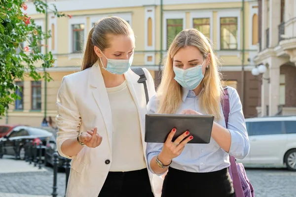 Mujeres de negocios que usan máscaras de protección médica con tableta digital —  Fotos de Stock