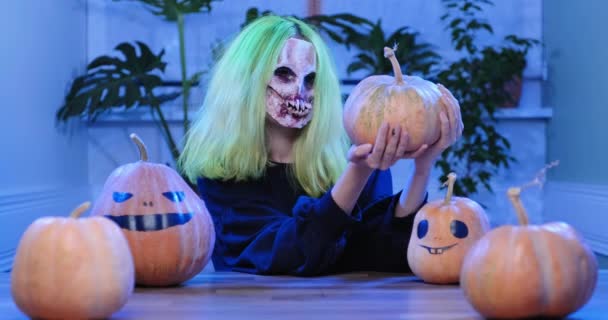 Halloween. Mladá žena v hrozné masce s dýněmi — Stock video