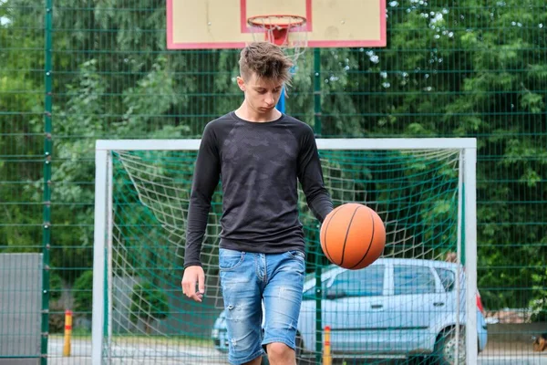 Outdoor portrait of teenage boy playing street basketball — Stock Photo, Image