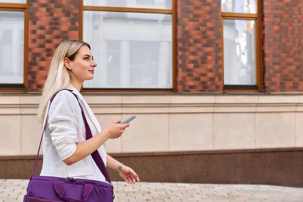 Młoda kobieta biznesu spaceruje po mieście rozmawiając przez telefon komórkowy — Zdjęcie stockowe