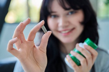 Bitkisel bitki kapsülünü ve şişeyi genç gülümseyen kadının ellerinde kapat. Beden terapisi, gıda takviyeleri, beslenme, sağlıklı beslenme, diyet, eczane, vitaminler, tedavi konsepti