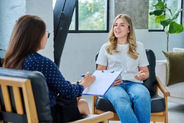 Psikolog terapistle seansta gülümseyen genç bir kadın. Psikoterapist danışmanı olan mutlu bir kadın hasta. Psikolojik hizmetler, bireysel terapi tedavi desteği