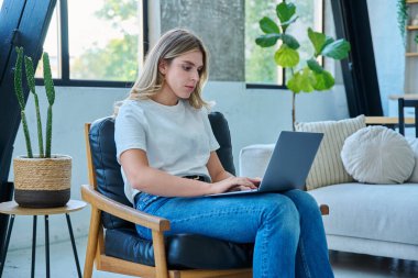 Genç bir kadının portresi sandalyede oturmuş ev içinde dizüstü bilgisayarda yazı yazıyor. Üniversite öğrencisi sınava hazırlanıyor, kadın bilgisayar kullanıyor, rahatlıyor sosyal medya blogunu okuyor, internetten alışveriş yapıyor.