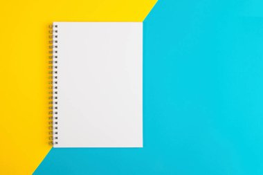 Mavi bir arka planda mavi kahve fincanı ve beyaz bir sayfa.