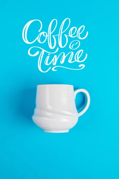 Blue coffee mug on a blue background with the text and a blank white page