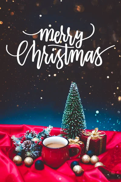 Kırmızı bardakta bir kahve Noel ışıkları ve mutlu noeller metni ile süsleme.