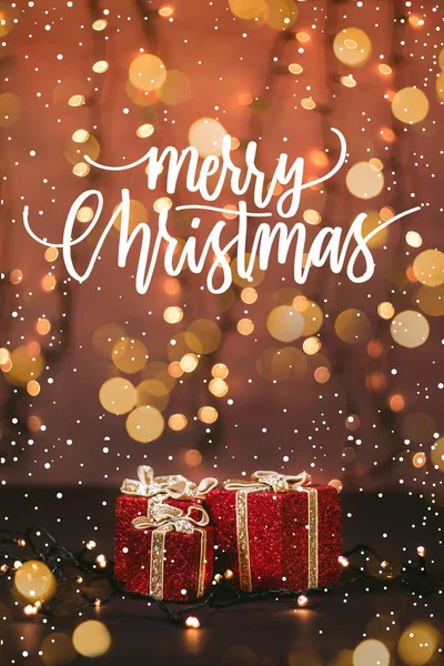 Güzel paketlenmiş hediyelerin, ışıkların ve karlı Noel alıntılarının fotoğrafını çek.