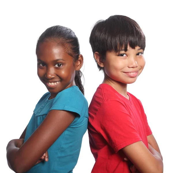 多种族男孩和女孩背靠背的双臂交叉 图库图片