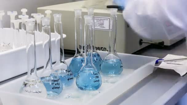 Bulbos Químicos Com Líquido Azul Estão Mesa Laboratório Para Testes — Vídeo de Stock