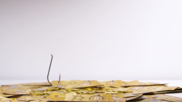 特写新鲜黄色比特币钞票捉住和举起与大金属钩反对白色背景 — 图库视频影像
