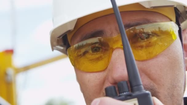 Sarı Gözlüklü Beyaz Başlıklı Fabrika Işçisi Taşınabilir Radyo Kullanarak Bilgi — Stok video