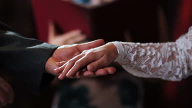 Düğün töreni sırasında sevgili gelini parmak kız beyaz dantelli elbise için altın yüzük closeup damat koyar