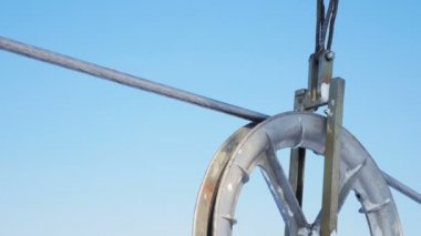 Sonsuz mavi gökyüzü karşı havada Merkez over küçük önde gelen tekerlek tarafından taşınan Closeup elektrik çelik kablo