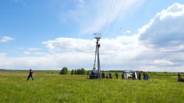 Yavaş çekim yetenekli itfaiyeciler mavi gökyüzüne karşı hızlı elektrik iletim hattını tamir ediyor.