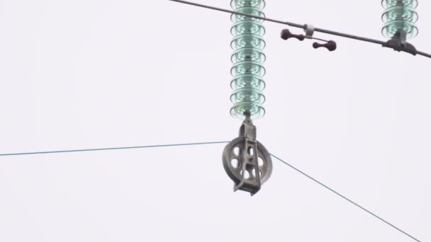 Изолятор с роликом тянет электрический провод проводящий ток — стоковое видео