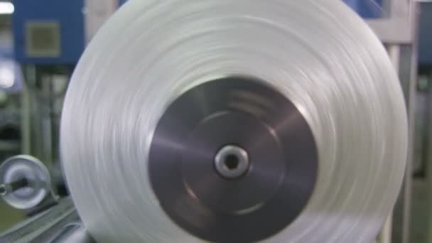 Closeup threads wind on rotating bobbin in factory — Stock Video