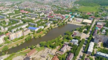 Resimsel mavi gökyüzü altında kamu binaları ile şehir arasında panoramik manzaralı geniş kahverengi su nehir geçiyor