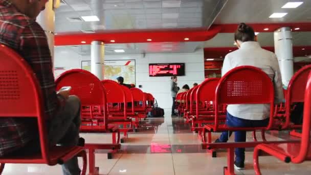 Arkaya Bakan Insanlar Kırmızı Koltuklarda Oturur Bekleme Salonundaki Dijital Ekrana — Stok video