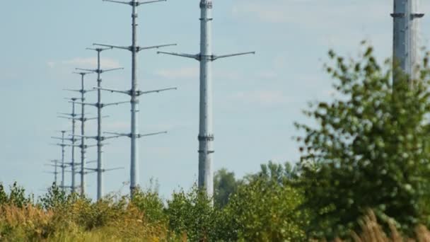 Moderne Hochspannungsmasten rudern vor blauem Himmel — Stockvideo