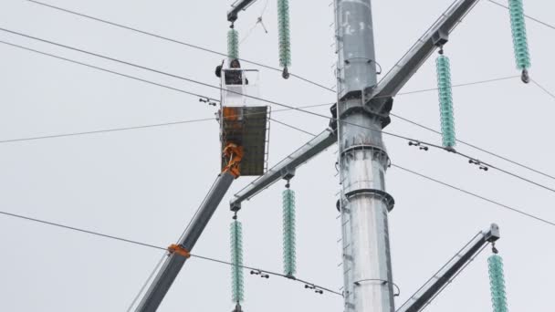 Lavoratori su linee elettriche fisse a terra sotto pioggia — Video Stock